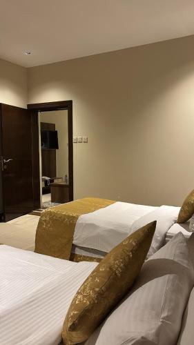 a hotel room with two beds and a mirror at سما الخليج للشقق المخدومة in Hafr Al-Batin