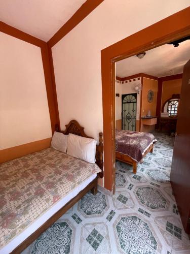 a room with two beds and a mirror at Hotel Plaza Macondo in Comonfort
