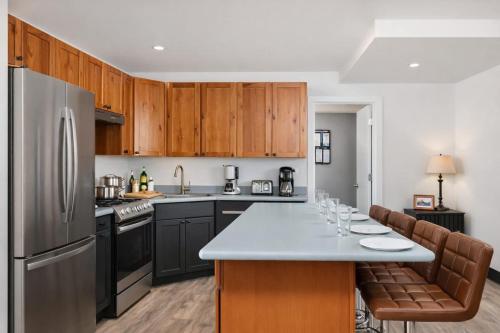 a kitchen with wooden cabinets and a stainless steel refrigerator at Charming Appleton Condo Downtown Modern Loft in Appleton