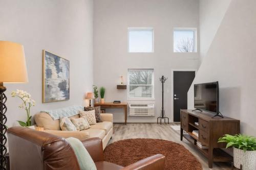 a living room with a couch and a tv at Charming Appleton Condo Downtown Modern Loft in Appleton