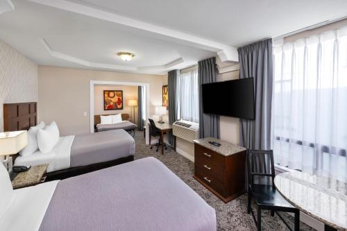 a hotel room with two beds and a flat screen tv at Quality Inn & Suites in Vancouver