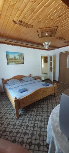 a large bed in a room with a wooden ceiling at Річкова Поляна in Polyana