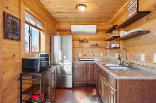 a kitchen with a stainless steel refrigerator and a sink at Cozy Cub Cabin, Wilderness Retreat Williams AZ near Grand Canyon, Fire pit in Williams