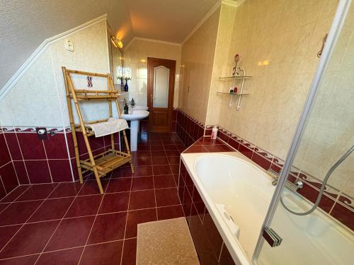 a bathroom with a bath tub and a sink at Rigódal Vendégház in Eger