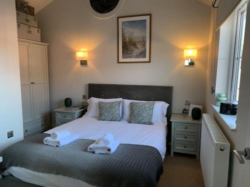 a bedroom with a bed with two towels on it at Lakeside Retreat, The Bay Filey, 2 bedrooms with ensuites, parking with EV charger in Filey