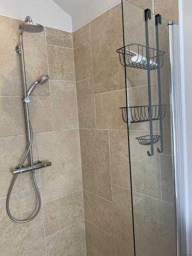 a shower with a glass door in a bathroom at Lakeside Retreat, The Bay Filey, 2 bedrooms with ensuites, parking with EV charger in Filey