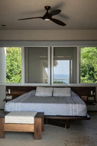 a bedroom with a bed and a ceiling fan at Oceanfront Designer Penthouse, Private Pool in Ixtapa