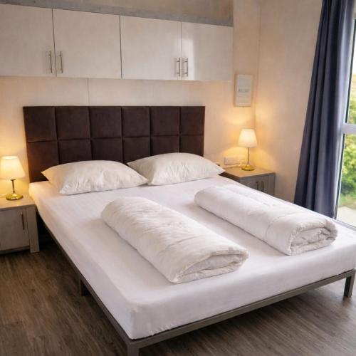 a large white bed with two pillows on it at Luxus Chalet im schönen Recratiepark De Veerstal in Rheden