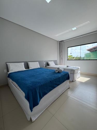 a white bedroom with a large bed and a large window at Oceane Norte Hotel in Parnaíba