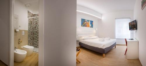 a bedroom with a bed and a bathroom with a tub at RomeCookSea Guest House in Lido di Ostia