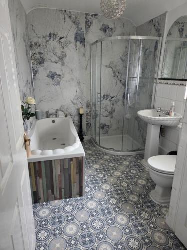 a bathroom with a sink and a shower and a toilet at Titanic Sailortown Belfast City Centre townhouse in Belfast