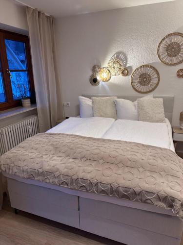 a bedroom with a bed with white sheets and a window at Alpenglück in Immenstadt im Allgäu