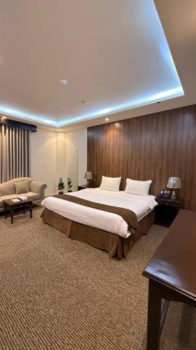 a large bedroom with a large bed and a couch at شقق بوابة العالية للشقق الفندقية in Medina