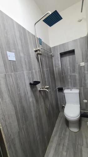 a bathroom with a toilet and a shower at Exodus Hotel & Restaurant in Aiyetoro
