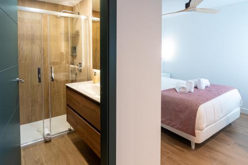 a bathroom with a bed and a shower and a sink at Geysotur Ribera Luxury Suites in Córdoba