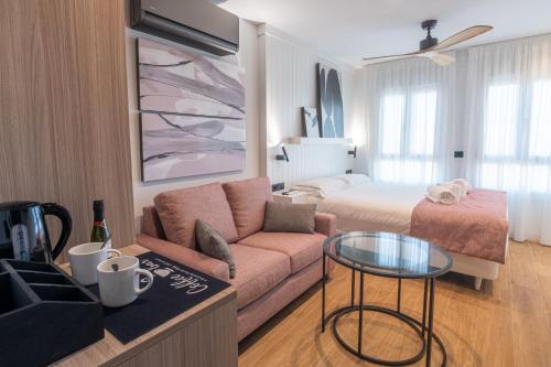 a living room with a couch and a bed at Geysotur Ribera Luxury Suites in Córdoba