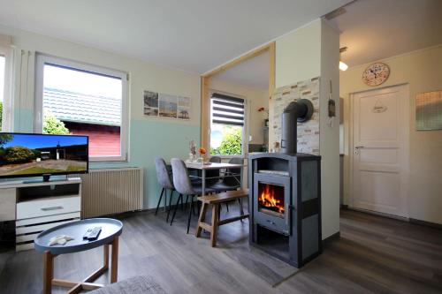 a living room with a fireplace and a dining room at Neu Süllitz, Bungalow 50 in Neu Süllitz