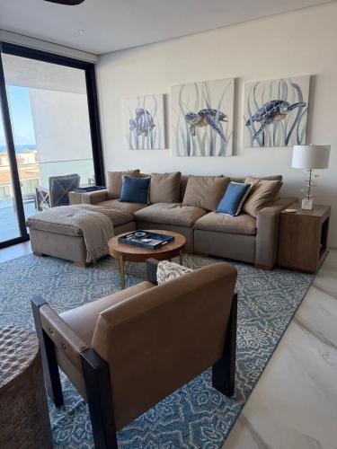 a living room with a couch and a table at New Golf Course Condo with Ocean Views in San José del Cabo