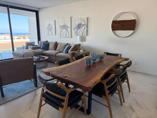 a living room with a wooden table and chairs at New Golf Course Condo with Ocean Views in San José del Cabo