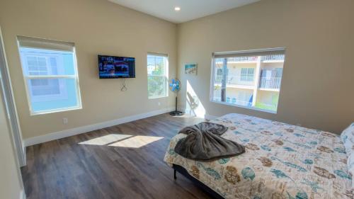 a bedroom with a bed and two windows at Steps to Beach Private Pool 2 Big Levels in South Padre Island
