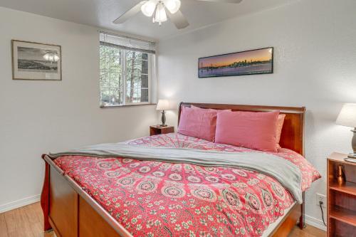 a bedroom with a bed with a red comforter at Explore the Coconino Forest! Flagstaff Cottage in Flagstaff