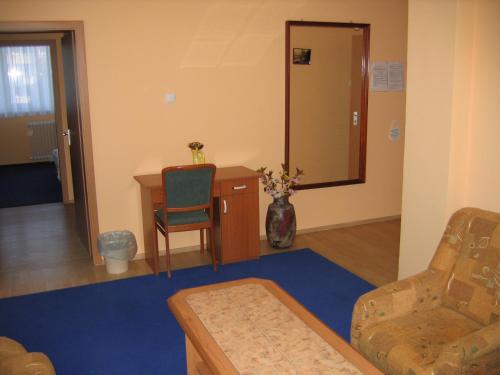 a living room with a desk and a chair at Hotel Ózd in Ózd