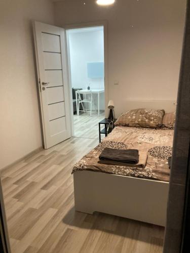 a bedroom with a bed and a door with a desk at Makosieje Resort-20m od brzegu,wi-fi ,widok na jezioro in Makosieje