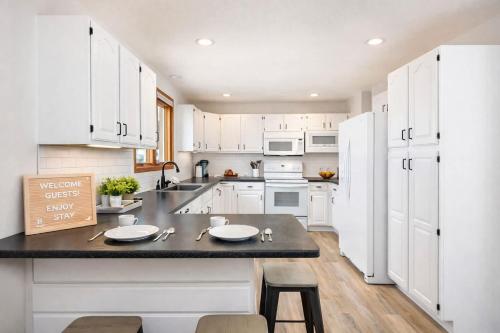 a kitchen with white cabinets and a black counter top at East Side 3 Br 2 full bath King Bed in Appleton