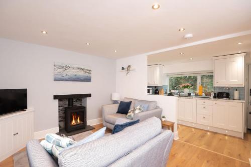 a living room with a couch and a fireplace at Tŷ Gwyn Bach, Conwy in Conwy