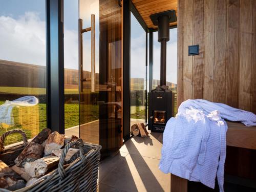a bedroom with a bed and a fireplace with a view at Middle Longlands in Cartmel