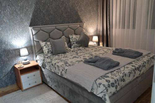 a bedroom with a large bed with two pillows on it at Stan na dan Pancevo 3 in Pančevo
