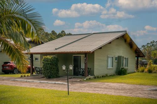 a small green house with a metal roof at Hotel Acqua Lokos in Arroio Teixeira