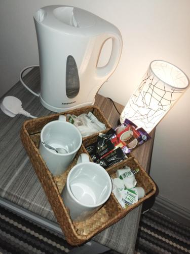 a tray with a tea pot and bowls on a table at The Commodore Hotel in Nottingham