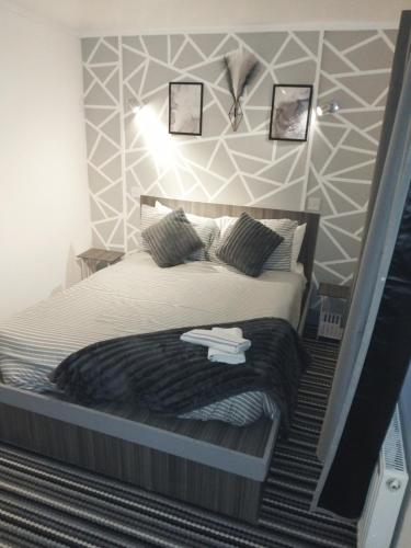 a bedroom with a large bed with two towels on it at The Commodore Hotel in Nottingham