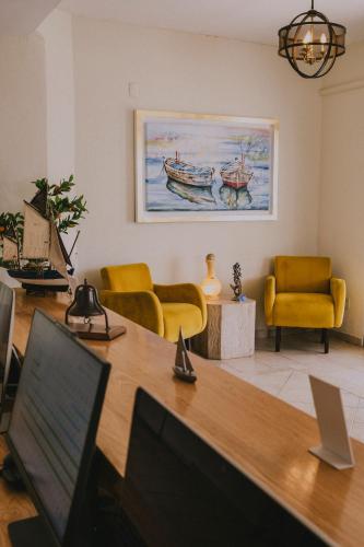 a living room with yellow chairs and a desk with a laptop at Santa Maria del Cabo in San José del Cabo