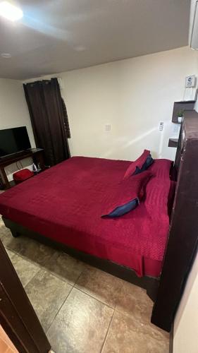 a bedroom with a large red bed with red sheets at Chocolate condo in San Felipe