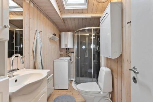 a bathroom with a toilet and a shower and a sink at LL269-Tranekaer-Rollikevej-20-a in Stoense
