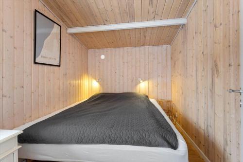 a bed in a small room with wooden walls at LL269-Tranekaer-Rollikevej-20-a in Stoense