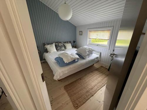 a bedroom with a bed with pillows and a window at AE321-Aeroskobing-Borgnaesvej-7 in Ærøskøbing