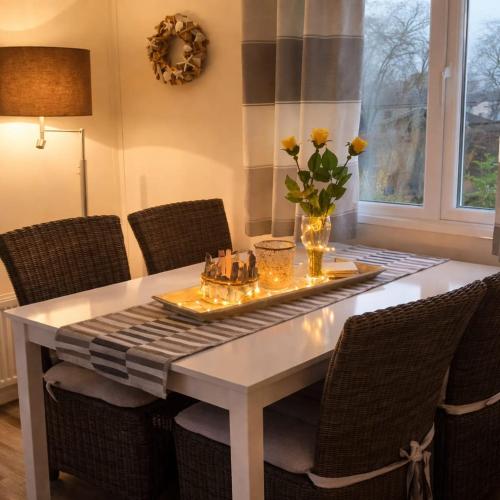 a dining room table with chairs and a table with flowers on it at Luxus Chalet im schönen Recratiepark De Veerstal in Rheden