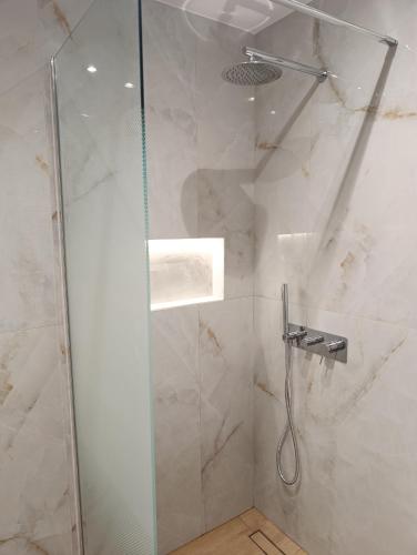 a bathroom with a shower with a glass door at katerina house in Ormos Panagias