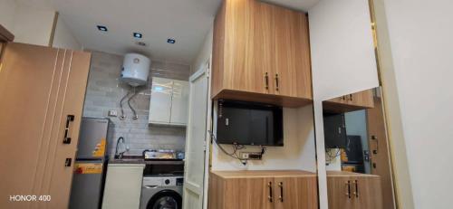 a small kitchen with a tv in a small apartment at Luna home in Petra
