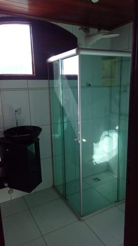 a glass shower in a bathroom with a sink at Chalé Privê Serrano em Gravatá in Gravatá