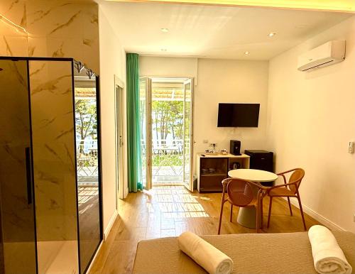 a living room with a table and a glass shower at Ripea Suites - Sul Mare in Montecorice