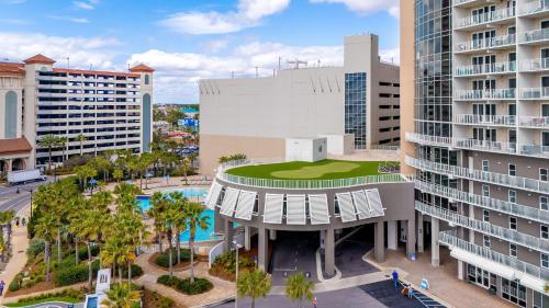 an aerial view of a building with a pool and buildings at Steps to the Sand - 1BR Condo in Panama City Beach