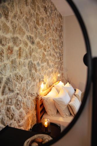 a room with a bed with a stone wall at Thalassa Apartments & Studios in Kavos