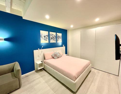 a blue bedroom with a bed and a chair at Residenza SubitoSanto - Appartamento 1G "Antenore" in Padova