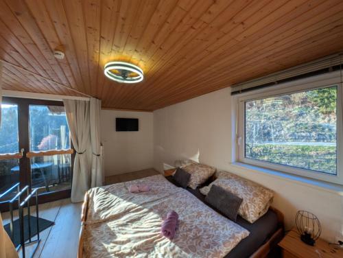 a bedroom with a bed and a large window at Herzogberghof in Kindberg