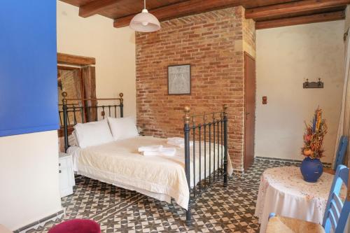 a bedroom with a bed and a brick wall at Traditional Villa with pool in Sfakia in Ímbros