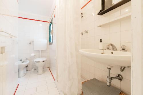 a white bathroom with a sink and a toilet at Levanto lodge in Levanto